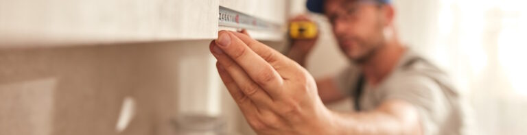 contractor measuring kitchen cabinets